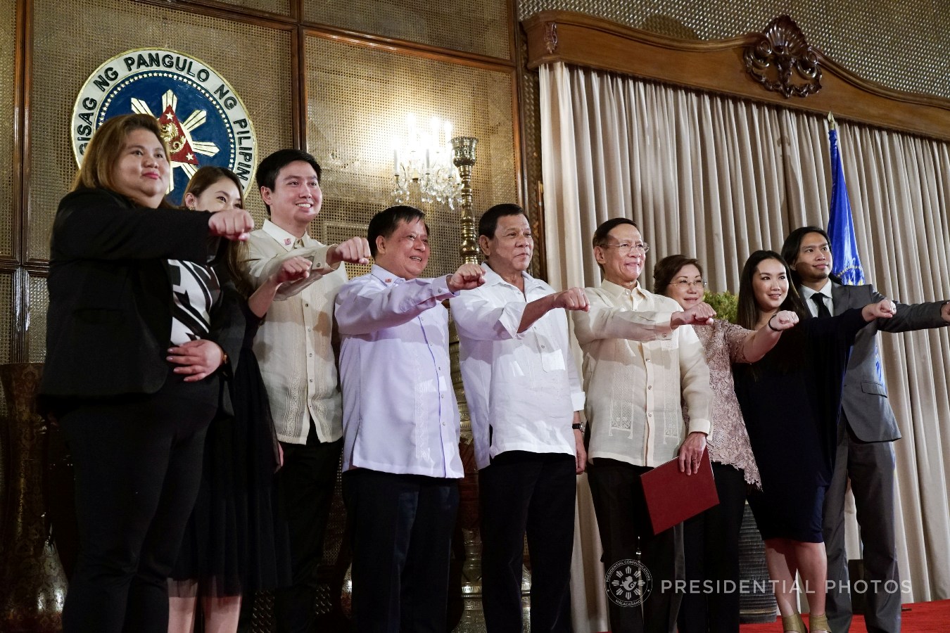 President Rodrigo Roa Duterte flashes his signature pose with newly appointed Health Secretary Francisco Duque III as well as his family and relatives following the oath-taking ceremony in Malacañan Palace on November 6, 2017. KING RODRIGUEZ/PRESIDENTIAL PHOTO