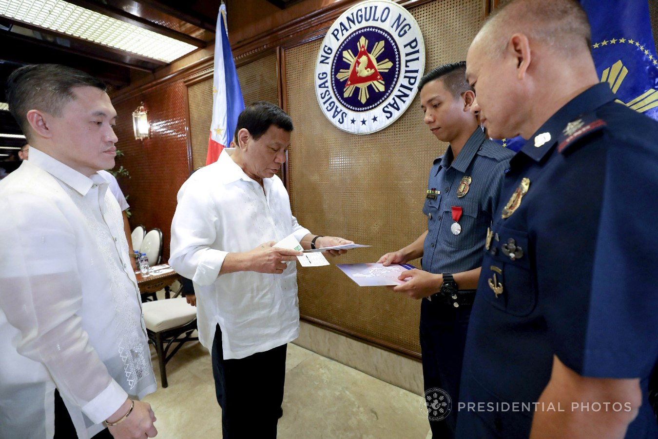 President Rodrigo Roa Duterte provides additional incentives to Order of Lapu-Lapu, Kampilan Medal awardee PO1 Ronald Anicete on the sidelines of the Joint Armed Forces of the Philippines (AFP)- Philippine National Police (PNP) Command Conference in Malacañan Palace on November 6, 2017. Anicete was stabbed by a man who resisted arrest in Caloocan City sometime in September. Also in the photo are Special Assistant to the President Christopher Lawrence Go and National Captial Region Police Office Direcor Oscar Albayalde. KARL NORMAN ALONZO/PRESIDENTIAL PHOTO
