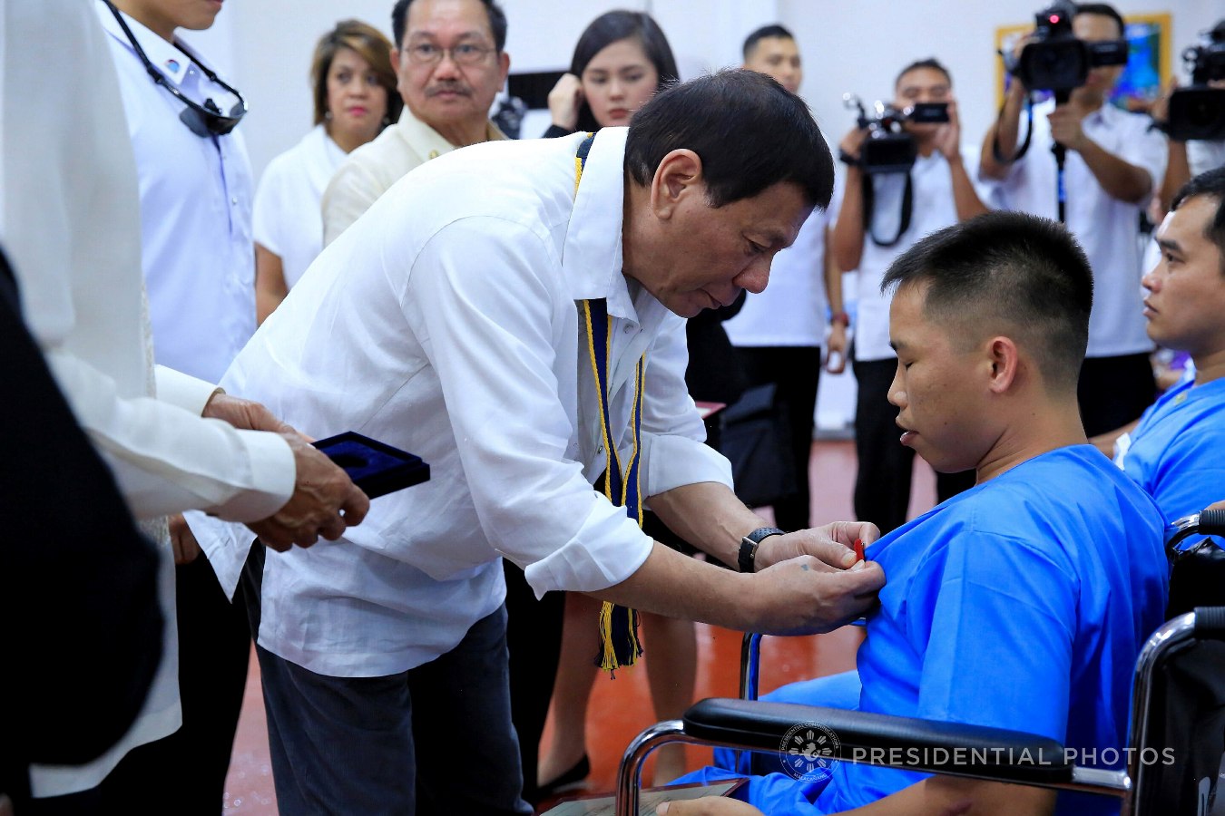 President Rodrigo Roa Duterte confers the Order of Lapu-Lapu Kampilan Medal on Cpl. Renato Eugosco who is among the beneficiaries of the Karne, Isda Supply Suporta sa Masa at Ekonomiya (KISS ME) Project during its launching at the Fort Andres Bonifacio in Taguig City on November 7, 2017. ALBERT ALCAIN/PRESIDENTIAL PHOTO