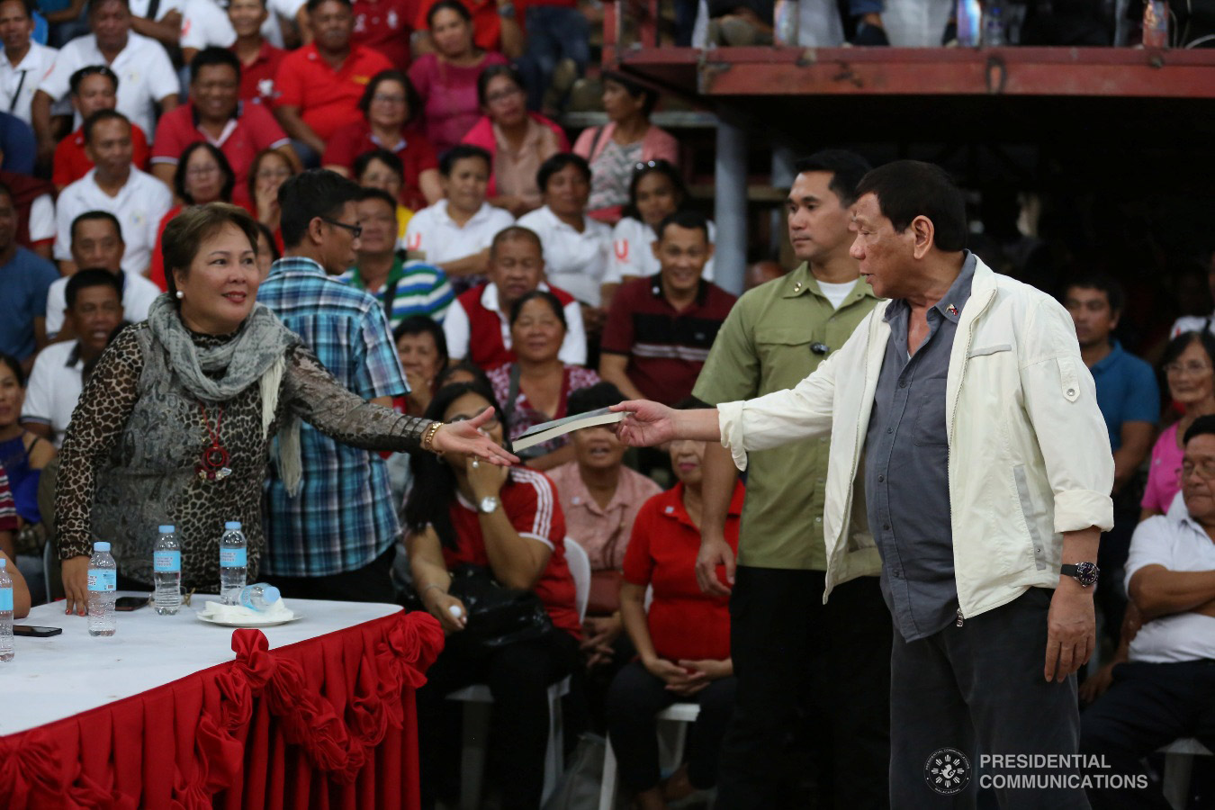 President Rodrigo Roa Duterte hands over a book to Philippine Charity Sweepstakes Office Board Member Sandra Cam, during the birthday celebration of Masbate Governor Antonio Kho at the Kalasangan Farm in Cataingan, Masbate on January 9, 2019. ALBERT ALCAIN/PRESIDENTIAL PHOTO