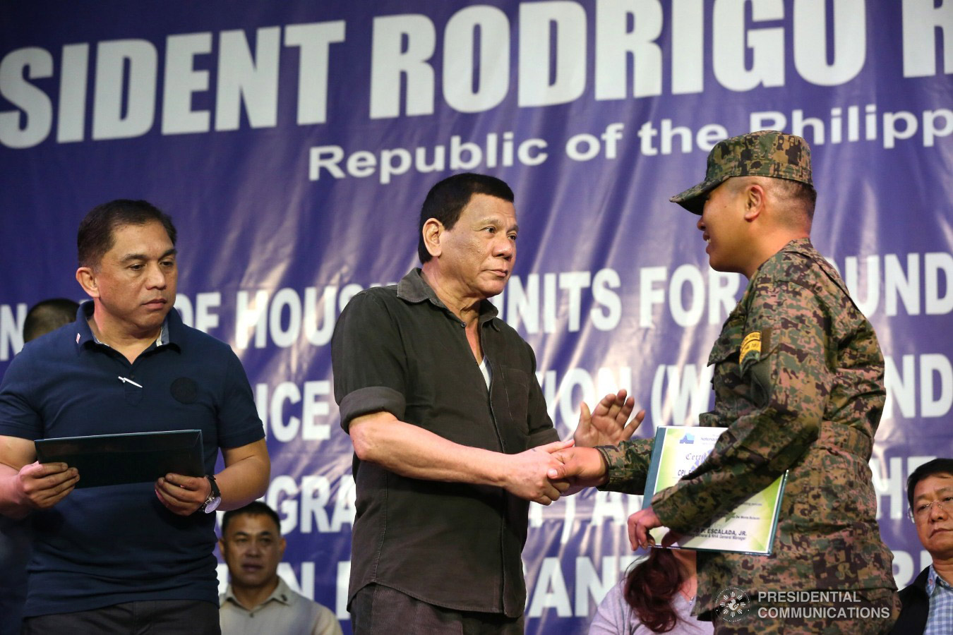 President Rodrigo Roa Duterte hands over a certificate of ownership to a wounded soldier who is one of the beneficiaries during the ceremonial turnover of housing units at the Pleasant View Residences in the City of San Jose del Monte, Bulacan on January 10, 2019. TOTO LOZANO/PRESIDENTIAL PHOTO