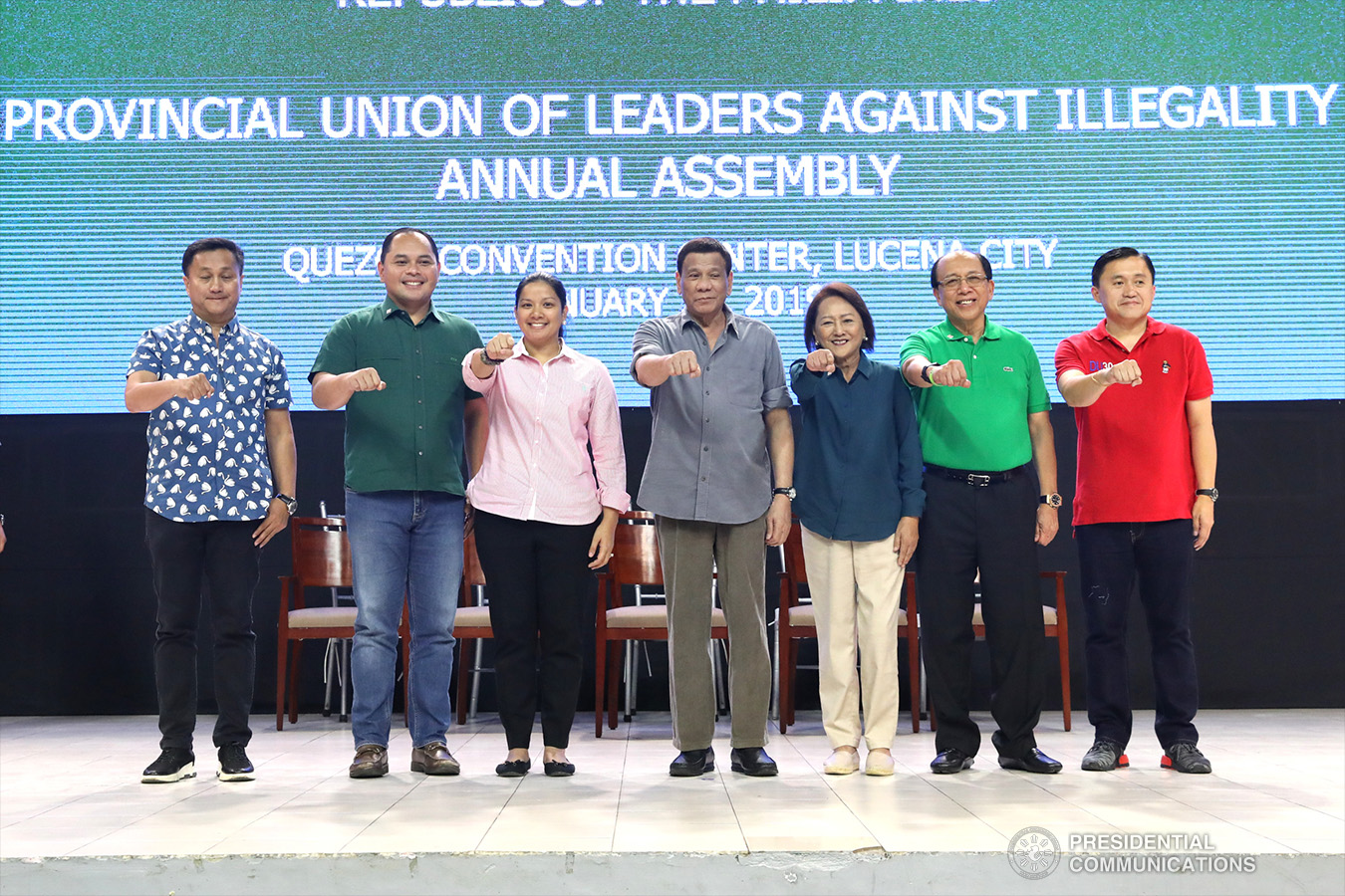 President Rodrigo Roa Duterte flashes his signature pose with Former Presidential Assistant on Political Affairs Francis Tolentino, Quezon Governor David Suarez,  Alliance of Organizations, Networks, and Associations (ALONA) Partylist Representative Anna Suarez, Former Third District of Quezon Province Representative Aleta Suarez, House Minority Floor Leader and Quezon Province Third District Representative Danilo Suarez, and Former Special Assistant to the President Christopher Lawrence "Bong" Go during the annual assembly of the Provincial Union of Leaders Against Illegality (PULI) at the Quezon Convention Center in Lucena City, province of Quezon on January 22, 2019. ACE MORANDANTE/PRESIDENTIAL PHOTO