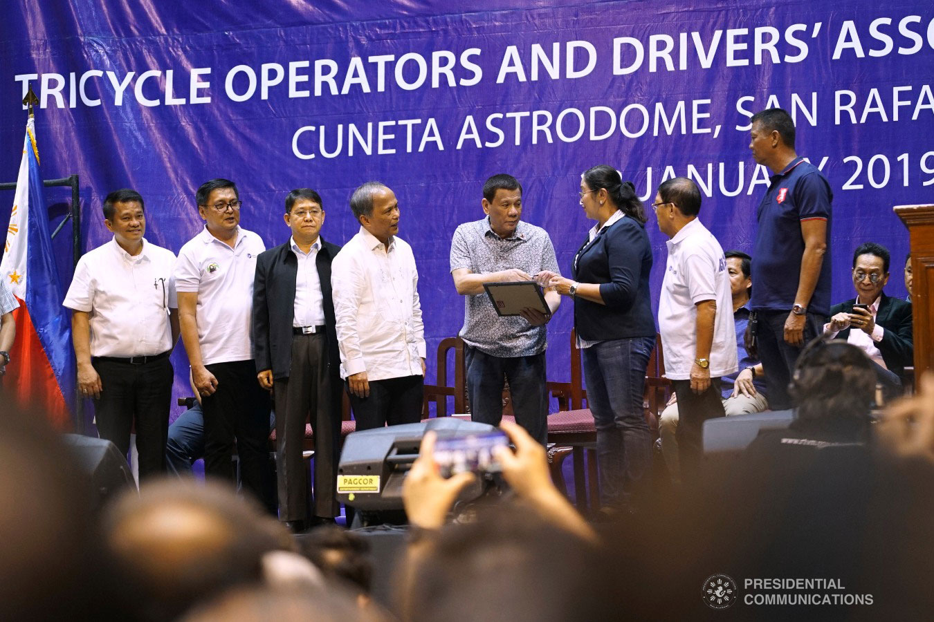 President Rodrigo Roa Duterte hands over a certificate for one electric tricycle unit to the local government of Mandaluyong City through Mayor Carmelita Abalos during the Tricycle Operators and Drivers’ Association (TODA) Summit at the Cuneta Astrodome in Pasay City on January 23, 2019. Also in the photo are NCR TODA Coalition President Ace Sevilla, Interior and Local Government Secretary Eduardo Año and Energy Secretary Alfonso Cusi. KING RODRIGUEZ/PRESIDENTIAL PHOTO