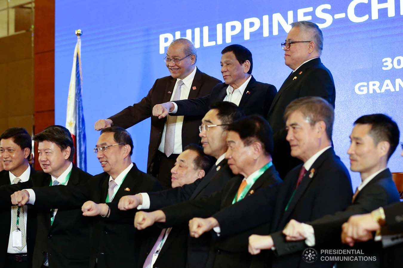 President Rodrigo Roa Duterte strikes his signature pose with Trade and Industry Secretary Ramon Lopez, Philippine Ambassador to the People's Republic of China Jose Sta. Romana, and the attendees during the Philippines-China Business Forum at the Grand Hyatt Hotel in Beijing on August 30, 2019. RICHARD MADELO/ PRESIDENTIAL PHOTO