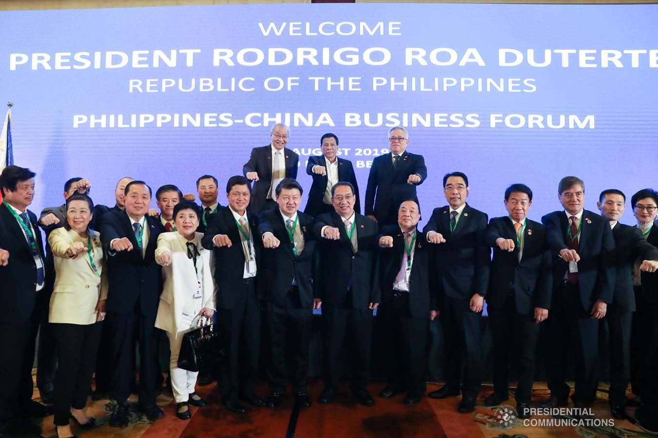President Rodrigo Roa Duterte strikes his signature pose with Trade and Industry Secretary Ramon Lopez, Philippine Ambassador to the People's Republic of China Jose Sta. Romana, and the attendees during the Philippines-China Business Forum at the Grand Hyatt Hotel in Beijing on August 30, 2019.  REY BANIQUET/ PRESIDENTIAL PHOTO