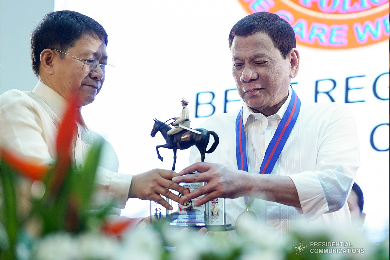 President Rodrigo Roa Duterte is assisted by Interior and Local Government Secretary Eduardo Año as he hands over a trophy to one of the awardees during the 118th Police Service Anniversary at Camp Brigadier General Rafael T. Crame in Quezon City on August 9, 2019. KING RODRIGUEZ/PRESIDENTIAL PHOTO