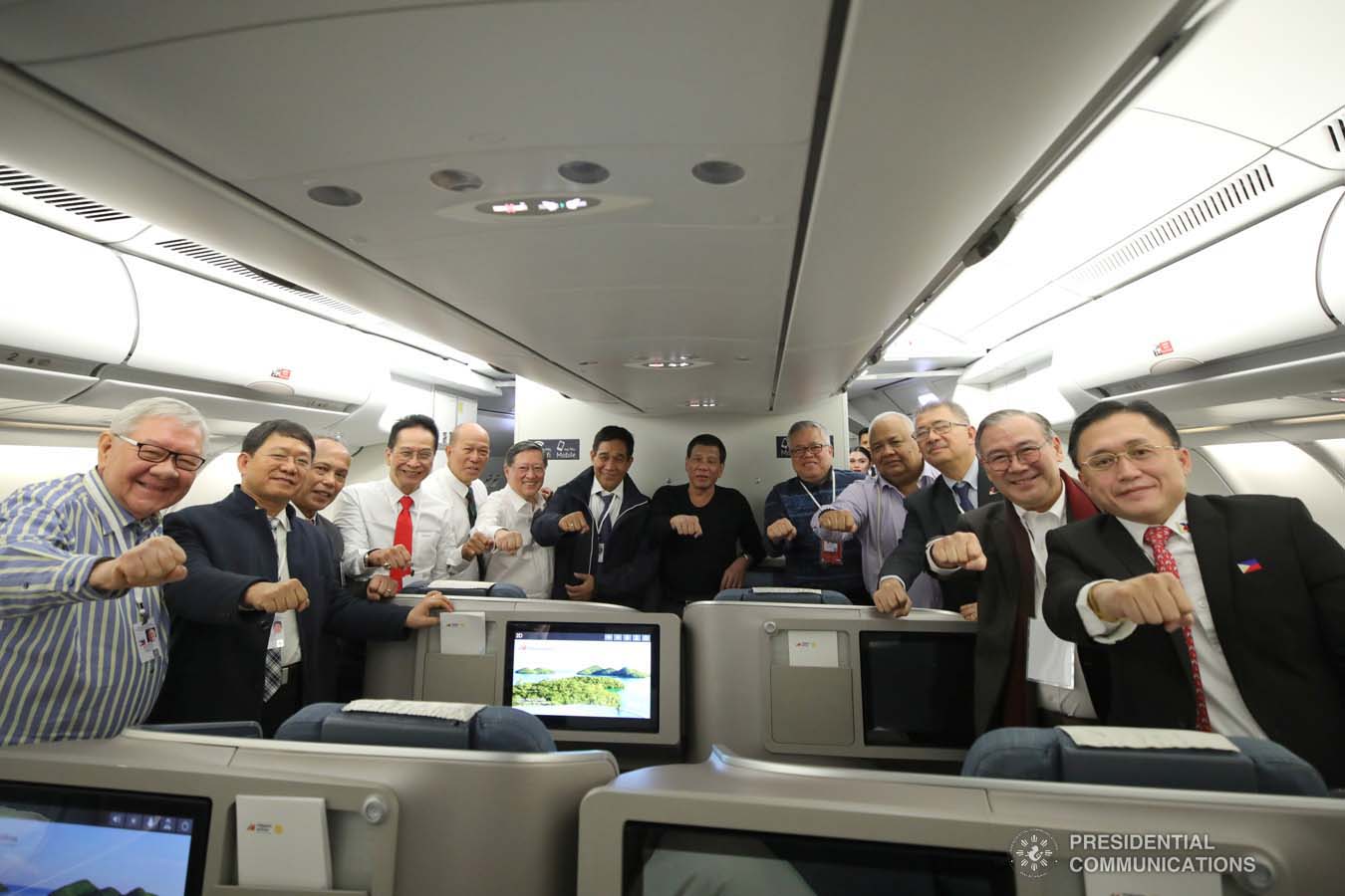 President Rodrigo Roa Duterte strikes his signature pose with the members of his delegation while on board a plane bound for Sochi, Russia on October 2, 2019. KING RODRIGUEZ/PRESIDENTIAL PHOTO