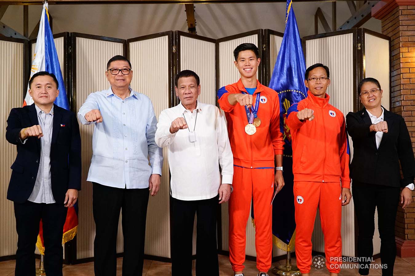 President Rodrigo Roa Duterte strikes his signature pose with 30th Summer Universiade Pole Vault Gold Medalist Ernest Obiena during their meeting at the Malago Clubhouse in Malacañang on October 16, 2019. Also in the photo are Senate Committee on Sports Chair Senator Christopher "Bong" Go and Philippine Sports Commission Chairman William Ramirez. KING RODRIGUEZ/PRESIDENTIAL PHOTO