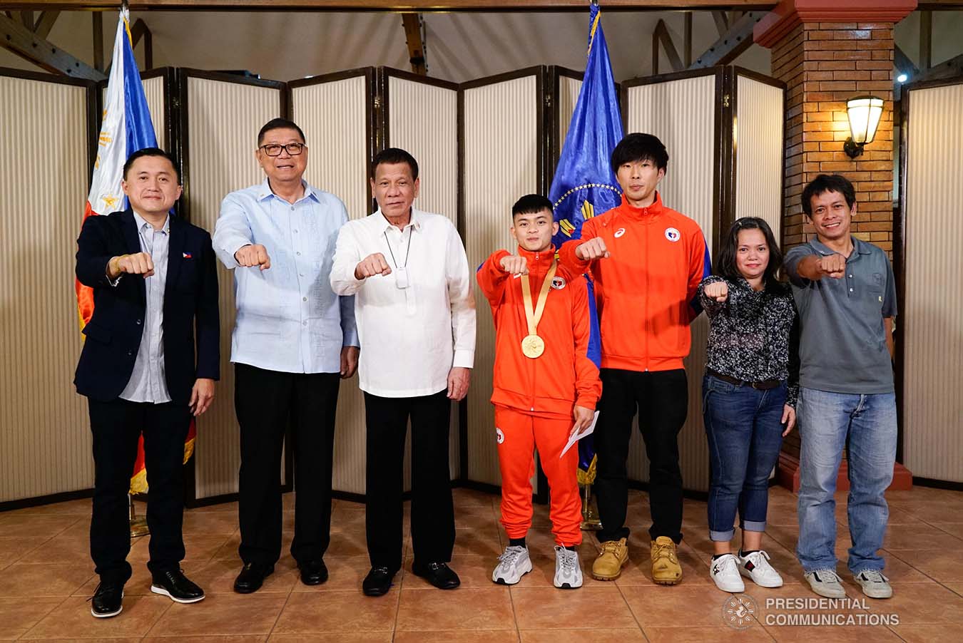 President Rodrigo Roa Duterte strikes his signature pose with 49th FIG Artistic Gymnastics World Championships Gold Medalist Carlos Yulo during their meeting at the Malago Clubhouse in Malacañang on October 16, 2019. Also in the photo are Senate Committee on Sports Chair Senator Christopher "Bong" Go and Philippine Sports Commission Chairman William Ramirez. KING RODRIGUEZ/PRESIDENTIAL PHOTO
