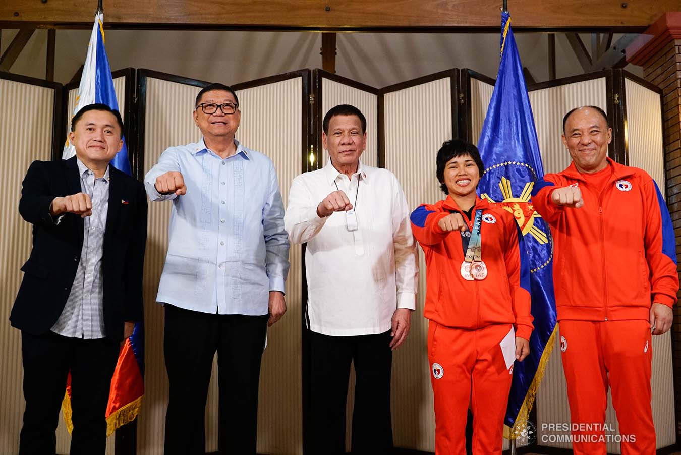 President Rodrigo Roa Duterte strikes his signature pose with 2019 Asian Weightlifting Championships China Silver Medalist Hidilyn Diaz during their meeting at the Malago Clubhouse in Malacañang on October 16, 2019. Also in the photo are Senate Committee on Sports Chair Senator Christopher "Bong" Go and Philippine Sports Commission Chairman William Ramirez. KING RODRIGUEZ/PRESIDENTIAL PHOTO