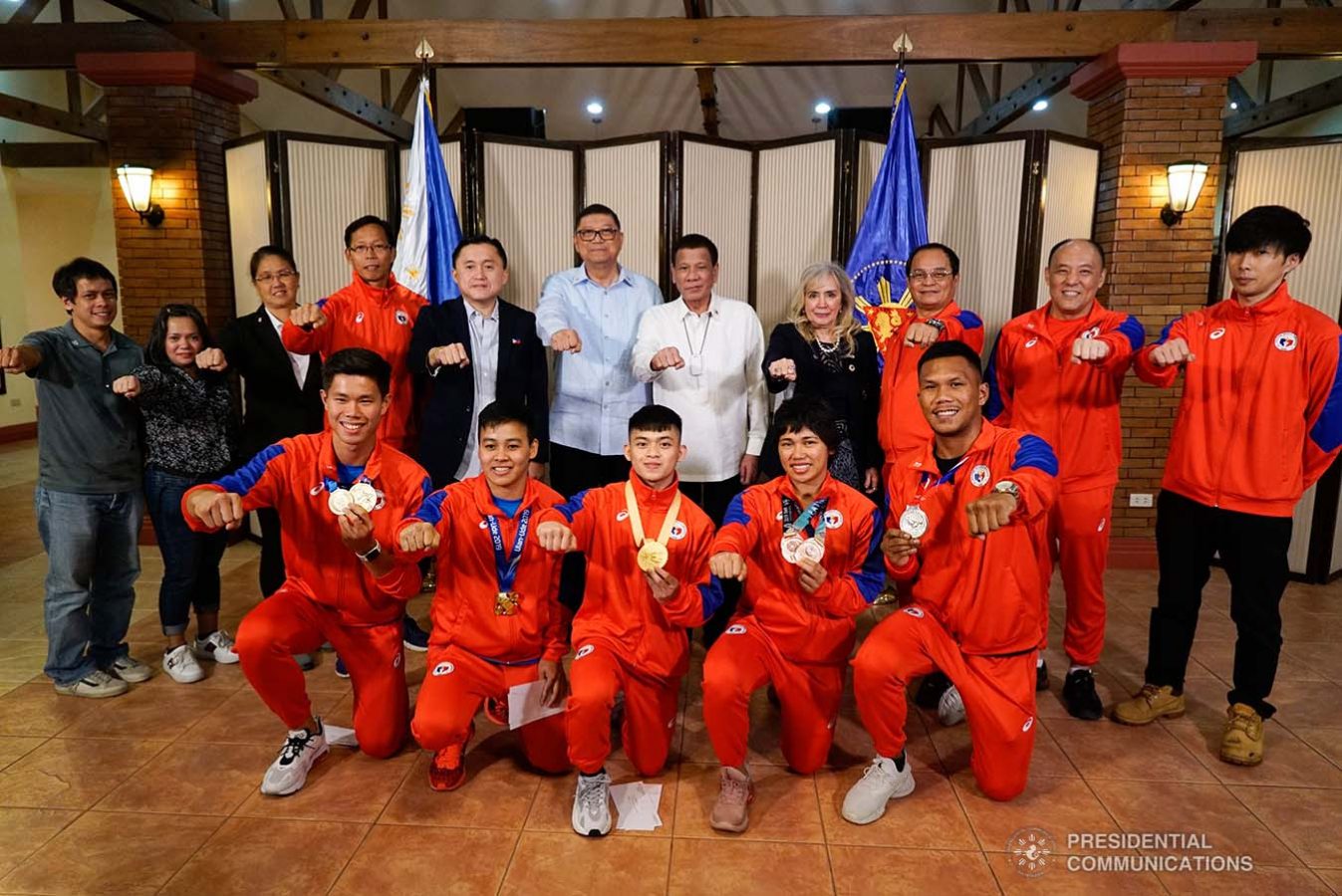 President Rodrigo Roa Duterte strikes his signature pose with the Filipino athletes who have brought home medals from various international competitions during their meeting at the Malago Clubhouse in Malacañang on October 16, 2019. KING RODRIGUEZ/PRESIDENTIAL PHOTO