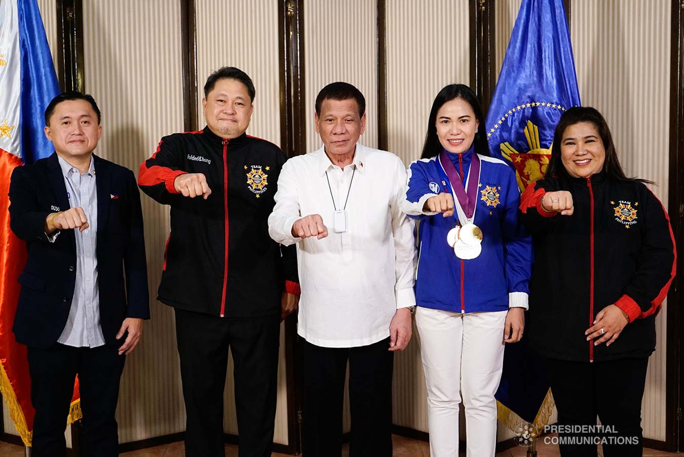 President Rodrigo Roa Duterte strikes his signature pose with World Championships of Performing Arts (WCOPA) medalist Joanna Miranda during their meeting at the Malago Clubhouse in Malacañang on October 16, 2019. Also in the photo are Senate Committee on Sports Chair Senator Christopher "Bong" Go, WCOPA National Director Gerardo Mercado, and Mary Mercado. KING RODRIGUEZ/PRESIDENTIAL PHOTO