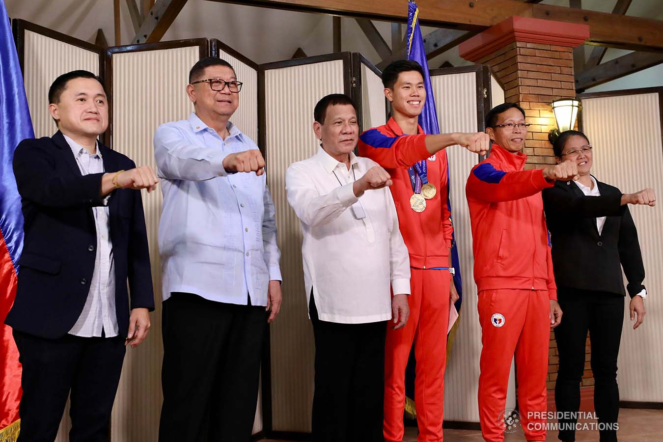 President Rodrigo Roa Duterte strikes his signature pose with 30th Summer Universiade Pole Vault Gold Medalist Ernest Obiena during their meeting at the Malago Clubhouse in Malacañang on October 16, 2019. Also in the photo are Senate Committee on Sports Chair Senator Christopher "Bong" Go and Philippine Sports Commission Chairman William Ramirez. RICHARD MADELO/PRESIDENTIAL PHOTO