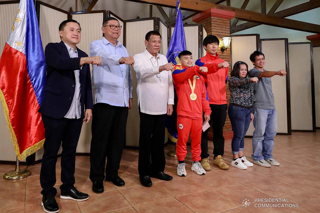 President Rodrigo Roa Duterte strikes his signature pose with 49th FIG Artistic Gymnastics World Championships Gold Medalist Carlos Yulo during their meeting at the Malago Clubhouse in Malacañang on October 16, 2019. Also in the photo are Senate Committee on Sports Chair Senator Christopher "Bong" Go and Philippine Sports Commission Chairman William Ramirez. RICHARD MADELO/PRESIDENTIAL PHOTO