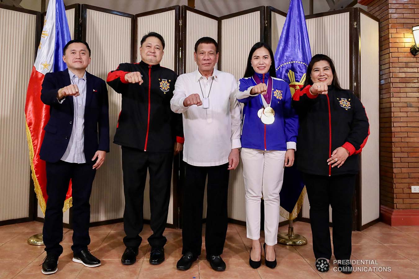 President Rodrigo Roa Duterte strikes his signature pose with World Championships of Performing Arts (WCOPA) medalist Joanna Miranda during their meeting at the Malago Clubhouse in Malacañang on October 16, 2019. Also in the photo are Senate Committee on Sports Chair Senator Christopher "Bong" Go, WCOPA National Director Gerardo Mercado, and Mary Mercado. RICHARD MADELO/PRESIDENTIAL PHOTO