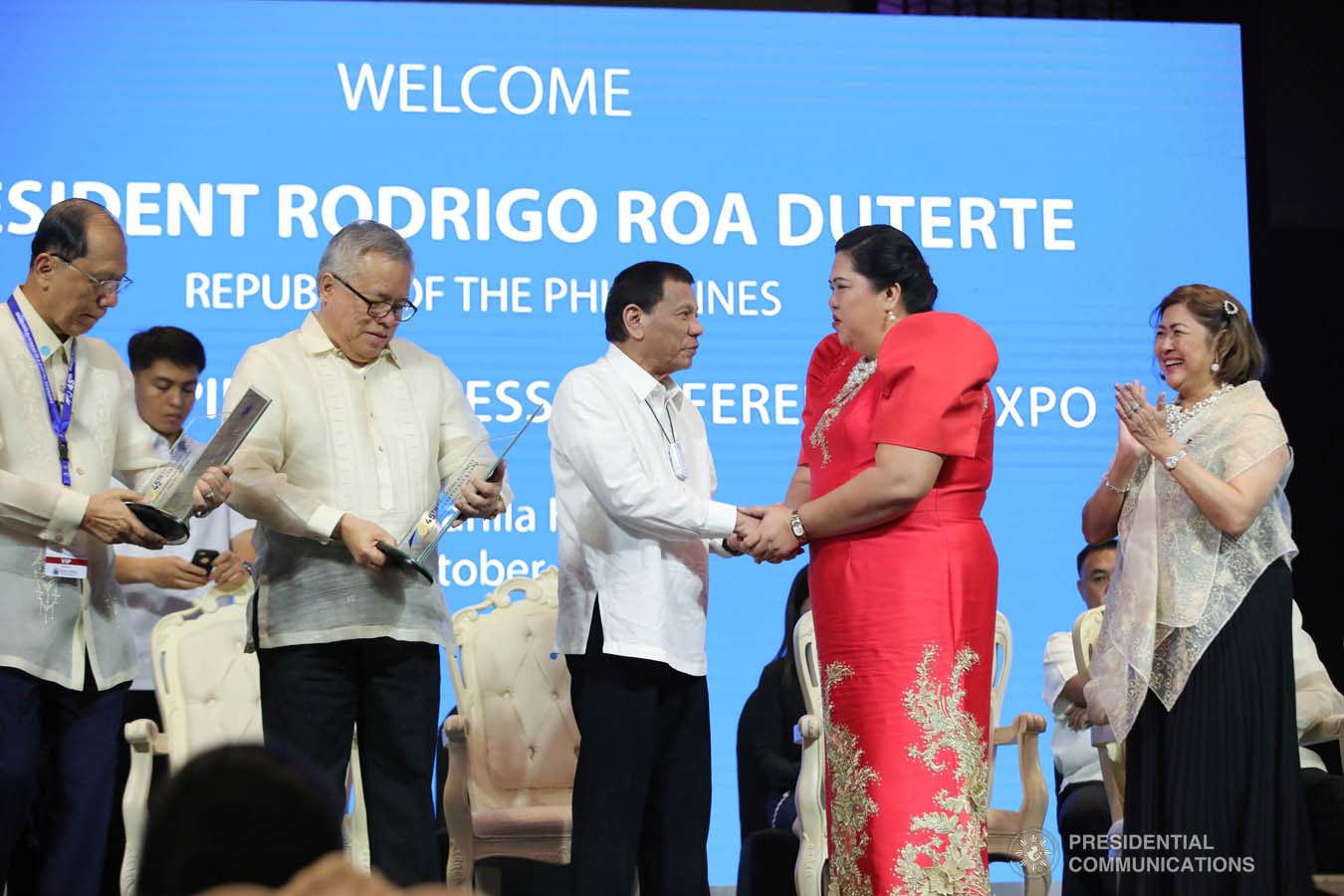 President Rodrigo Roa Duterte congratulates Bulacan Chamber of Commerce and Industry President Cristina Tuzon as she receives the  Most Outstanding Chamber in North Luzon and in the Philippines Provincial Level 1 Award during the 45th Philippine Business Conference and Expo at The Manila Hotel on October 17, 2019. Assisting the President during the awarding ceremony is Trade and Industry Secretary Ramon Lopez. ROBINSON NIÑAL JR./PRESIDENTIAL PHOTO