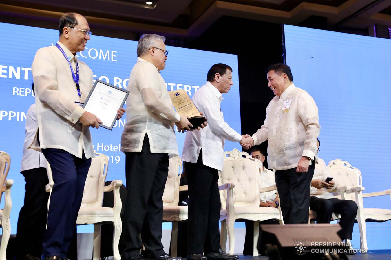 President Rodrigo Roa Duterte congratulates Guiguinto Municipal Mayor Ambrosio Cruz Jr. as he receives the Most Business-Friendly LGU Municipality Level 1 Award during the 45th Philippine Business Conference and Expo at The Manila Hotel on October 17, 2019. Assisting the President during the awarding ceremony is Trade and Industry Secretary Ramon Lopez. RICHARD MADELO/PRESIDENTIAL PHOTO