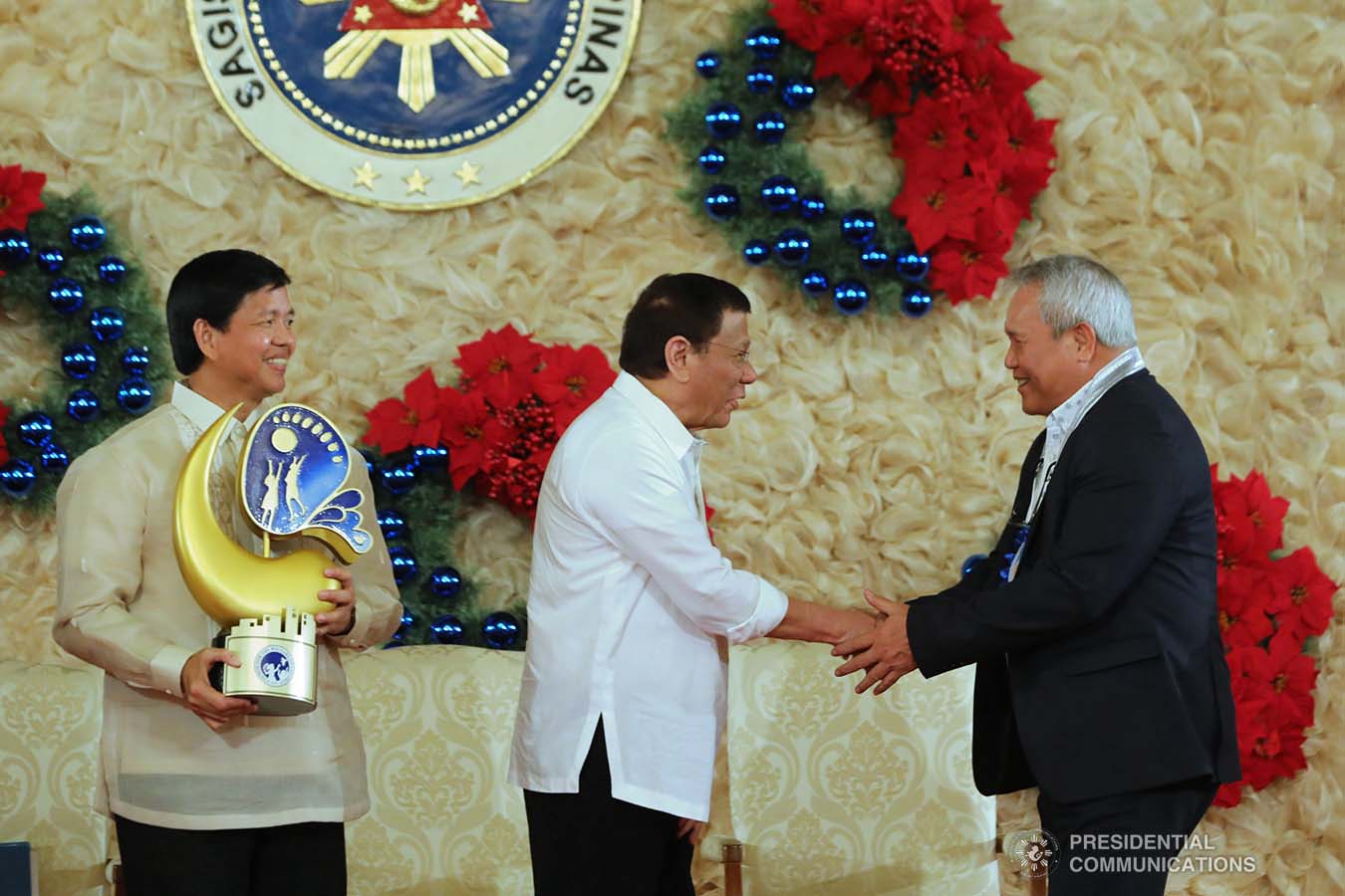 President Rodrigo Roa Duterte congratulates one of the awardees of the 2018 Presidential Award for Child-Friendly Municipalities and Cities (PACFMC) during the awarding ceremony at the Malacañan Palace on November 28, 2019. Assisting the President is Social Welfare and Development Secretary Rolando Bautista. VALERIE ESCALERA/PRESIDENTIAL PHOTO