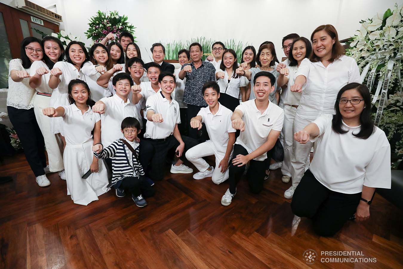 President Rodrigo Roa Duterte gestures his signature pose with the family of Elizabeth Gokongwei during his visit to condole with them at the Heritage Memorial Park in Taguig City on November 17, 2019. TOTO LOZANO/ PRESIDENTIAL PHOTO