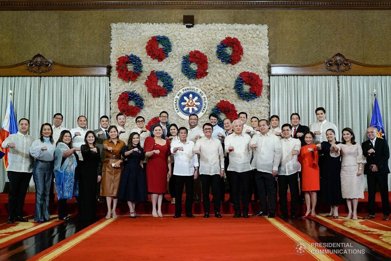 President Rodrigo Roa Duterte strikes his signature pose with the members of the House of Representatives during the ceremonial signing of the Postponement of the 2020 Barangay and Sangguniang Kabataan Elections Act and the Malasakit Center Act at the Malacañan Palace on December 3, 2019. KING RODRIGUEZ/PRESIDENTIAL PHOTO