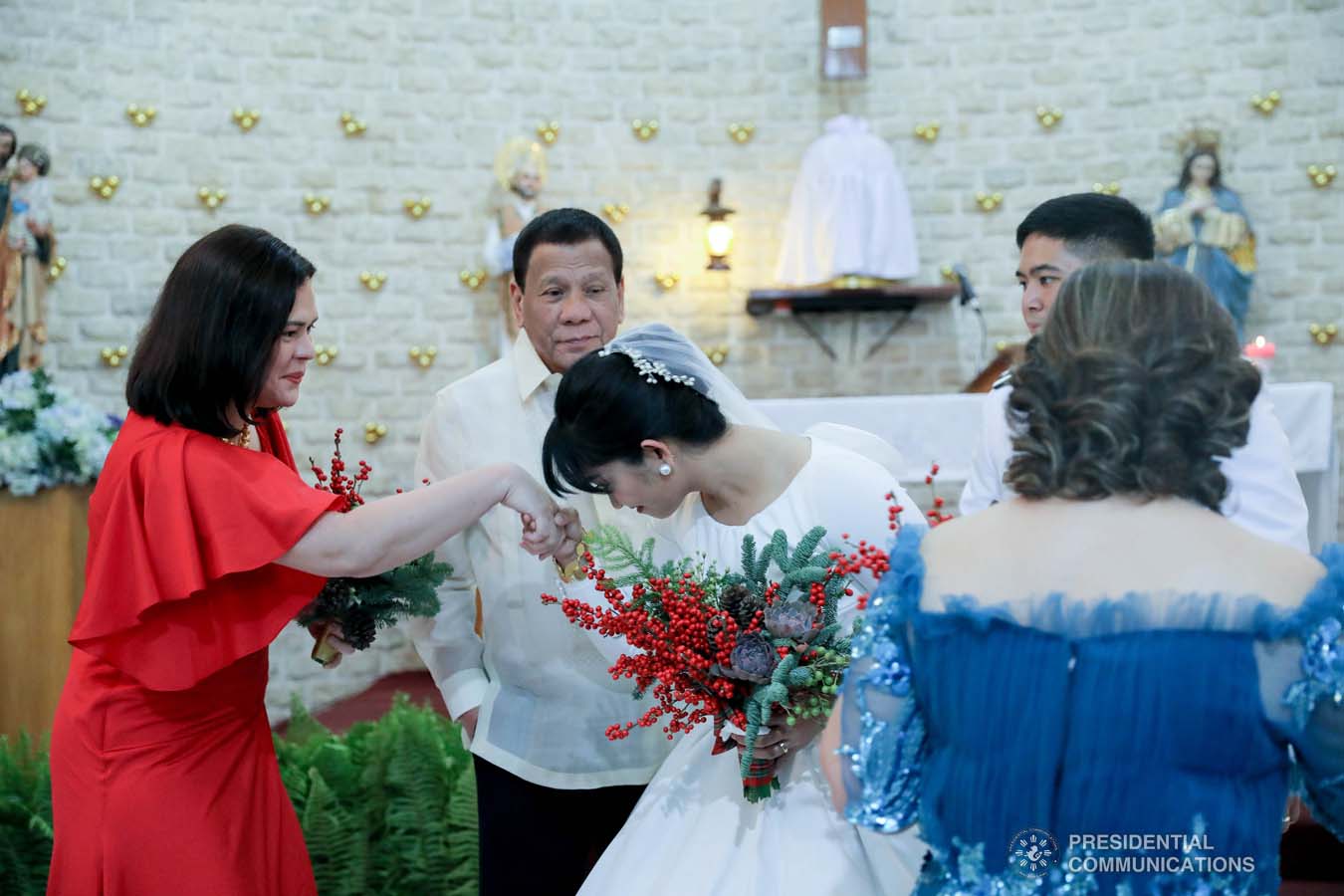 President Rodrigo Roa Duterte and daughter Davao City Mayor Sara Duterte-Carpio greets newlyweds Makkaria and First Lieutenant James Estoesta during the wedding at the St. Ignatius Chapel in Fort Gen. Gregorio H. del Pilar, Baguio City on December 8, 2019. VALERIE ESCALERA/PRESIDENTIAL PHOTO