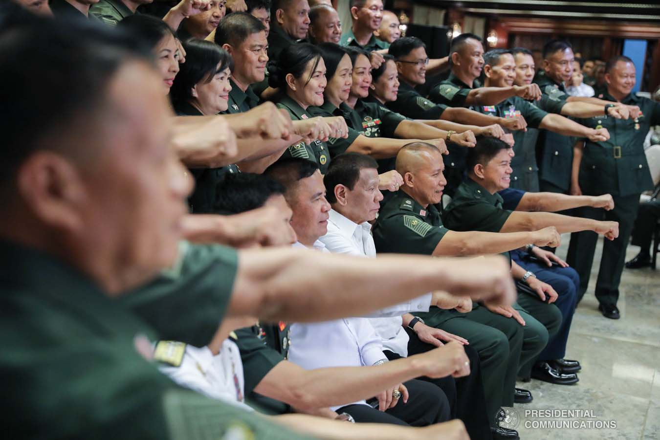 President Rodrigo Roa Duterte flashes his signature pose with the officers of the Armed Forces of the Philippines Council of the Sergeants Major during the Thanksgiving gathering he hosted at the Malacañan Palace on December 10, 2019. ALFRED FRIAS/PRESIDENTIAL PHOTO