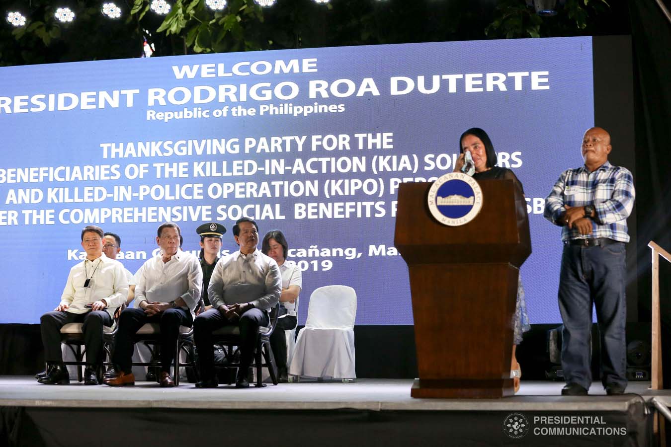 President Rodrigo Roa Duterte listens to the message of one of the beneficiaries of the killed-in-action (KIA) soldiers and killed-in-police operation (KIPO) personnel under the Comprehensive Social Benefits Program during the Thanksgiving party at the Malacañan Palace on December 10, 2019. RICHARD MADELO/PRESIDENTIAL PHOTO
