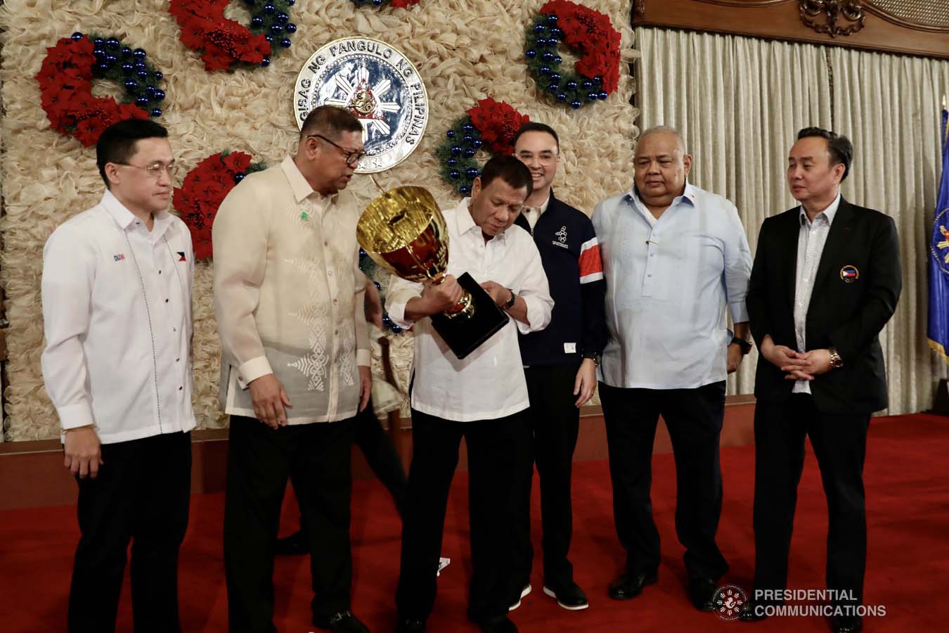 President Rodrigo Roa Duterte holds the overall champion trophy of the Philippine Team during the recognition of the 2019 Southeast Asian Games medalists at the Malacañan Palace on December 18, 2019. The Philippine Team emerged as overall champion in the recently-concluded 2019 SEA Games after garnering 149 golds, 117 silvers and 121 bronzes. With the President are Senator Christopher "Bong" Go, Philippine Sports Commission Chairman William Ramirez, Senator Alan Peter Cayetano, Executive Secretary Salvador Medialdea and Philippine Olympic Committee President and Cavite Eighth District Representative Abraham Tolentino. RICHARD MADELO/PRESIDENTIAL PHOTO