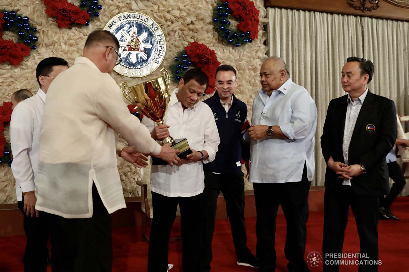 President Rodrigo Roa Duterte holds the overall champion trophy of the Philippine Team during the recognition of the 2019 Southeast Asian Games medalists at the Malacañan Palace on December 18, 2019. The Philippine Team emerged as overall champion in the recently-concluded 2019 SEA Games after garnering 149 golds, 117 silvers and 121 bronzes. With the President are Senator Christopher "Bong" Go, Philippine Sports Commission Chairman William Ramirez, Senator Alan Peter Cayetano, Executive Secretary Salvador Medialdea and Philippine Olympic Committee President and Cavite Eighth District Representative Abraham Tolentino. RICHARD MADELO/PRESIDENTIAL PHOTO