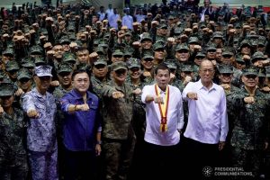 President Rodrigo Roa Duterte strikes his signature pose with Senator Christopher "Bong" Go, Defense Secretary Delfin Lorenzana and the officers and personnel of the Philippine Marine Corps during his visit at Fort Bonifacio in Taguig City on January 13, 2020. KING RODRIGUEZ/PRESIDENTIAL PHOTO