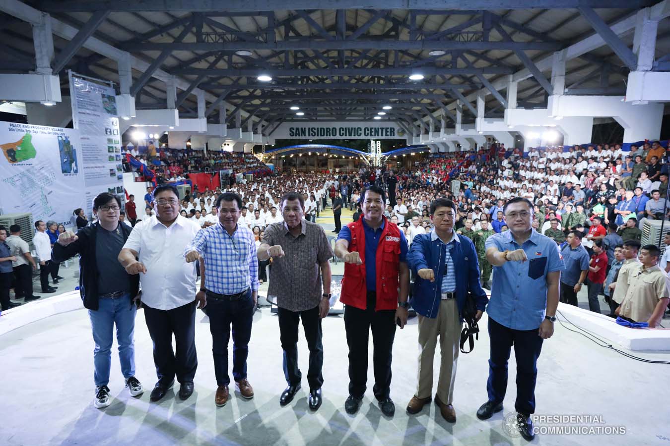 President Rodrigo Roa Duterte strikes his signature pose with Presidential Assistant for the Visayas Michael Dino, Agrarian Reform Secretary John Castriciones, Leyte Governor Leopoldo Petilla, Social Welfare and Development Secretary Rolando Bautista, Interior and Local Government Secretary Eduardo Año and Senator Christopher "Bong" Go during the distribution of benefits to former rebels at the San Isidro Central School in Leyte on January 23, 2020. KARL NORMAN ALONZO/PRESIDENTIAL PHOTO