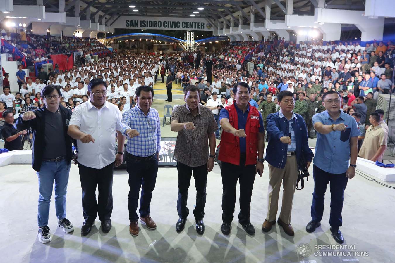 President Rodrigo Roa Duterte strikes his signature pose with Presidential Assistant for the Visayas Michael Dino, Agrarian Reform Secretary John Castriciones, Leyte Governor Leopoldo Petilla, Social Welfare and Development Secretary Rolando Bautista, Interior and Local Government Secretary Eduardo Año and Senator Christopher "Bong" Go during the distribution of benefits to former rebels at the San Isidro Central School in Leyte on January 23, 2020. VALERIE ESCALERA/PRESIDENTIAL PHOTO