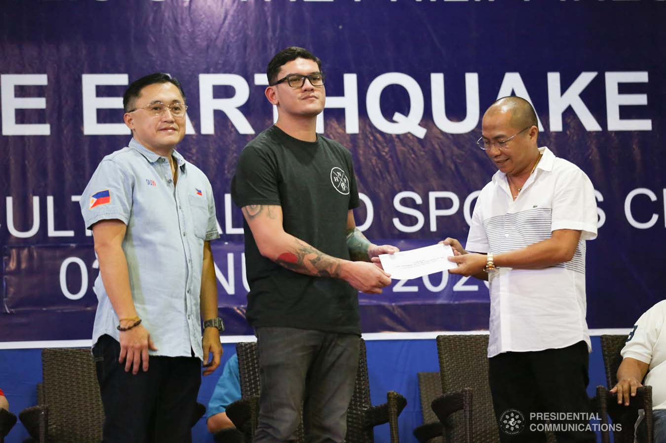 Davao City Vice Mayor Sebastian Duterte, who visited earthquake victims in Malalag, Davao del Sur on behalf of his father President Rodrigo Roa Duterte, turns over a check worth P5 million to Malalag Mayor Peter Valentin during a ceremony at the Malalag Cultural and Sports Center on January 3, 2020. Assisting the President's son is Senator Christopher "Bong" Go. ALBERT ALCAIN/PRESIDENTIAL PHOTO