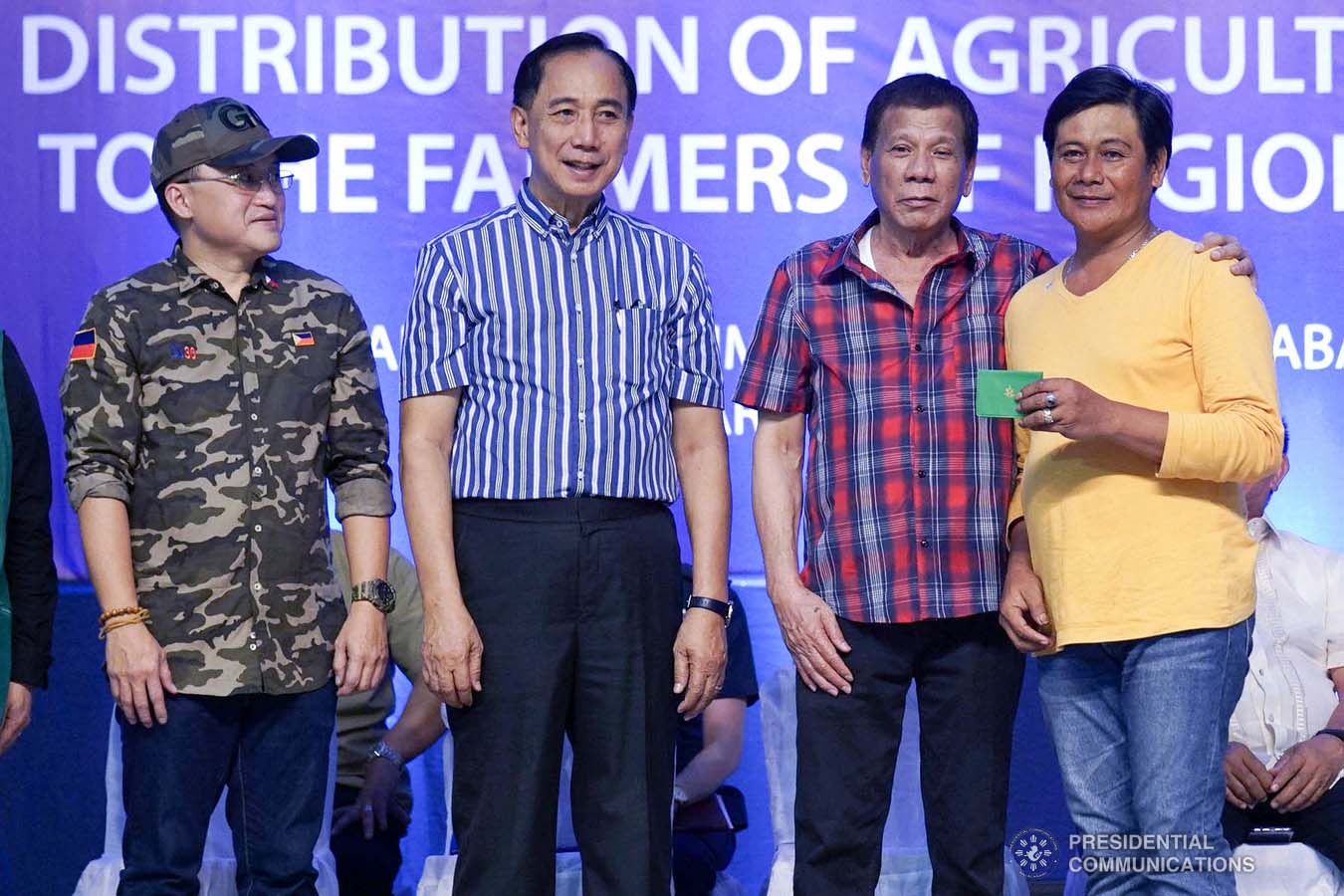 President Rodrigo Roa Duterte poses for posterity with one of the recipients of agricultural assistance during the ceremonial distribution at the Pigcawayan Municipal Gymnasium in Cotabato on January 10, 2020. Also in the photo are Senator Christopher "Bong" Go and Agriculture Secretary William Dar. ARMAN BAYLON/PRESIDENTIAL PHOTO