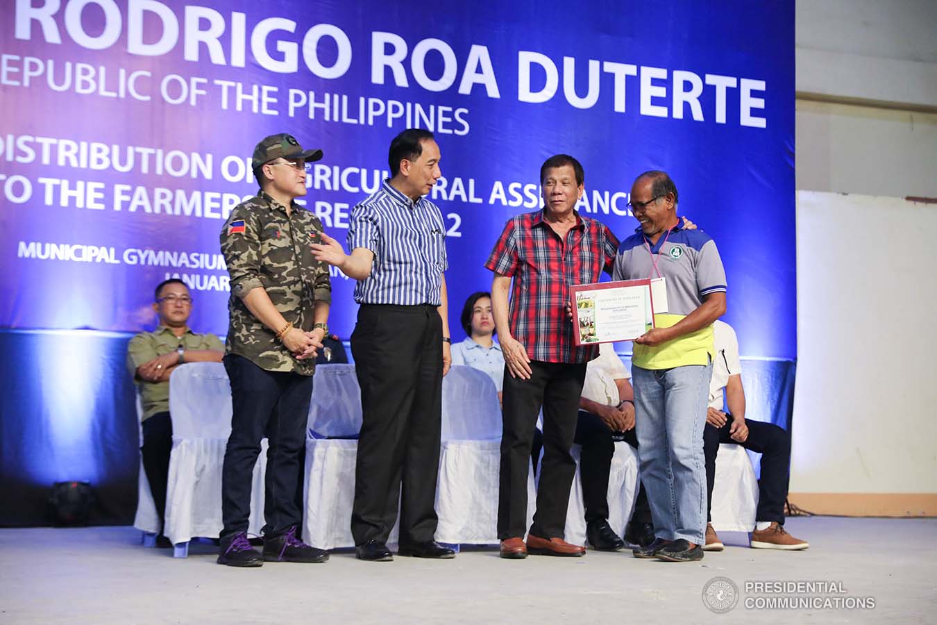 President Rodrigo Roa Duterte shares a light moment with one of the recipients of agricultural assistance during the ceremonial distribution at the Pigcawayan Municipal Gymnasium in Cotabato on January 10, 2020. Also in photo are Senator Christopher "Bong" Go and Agriculture Secretary William Dar. ROBINSON NIÑAL JR./PRESIDENTIAL PHOTO