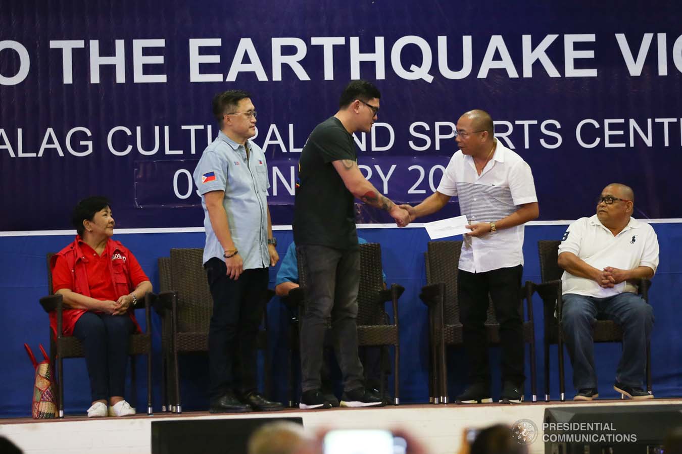 Davao City Vice Mayor Sebastian Duterte, who visited earthquake victims in Malalag, Davao del Sur on behalf of his father President Rodrigo Roa Duterte, turns over a check worth P5 million to Malalag Mayor Peter Valentin during a ceremony at the Malalag Cultural and Sports Center on January 3, 2020. Assisting the President's son is Senator Christopher "Bong" Go. KARL NORMAN ALONZO/PRESIDENTIAL PHOTO
