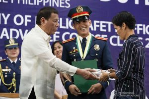 President Rodrigo Roa Duterte hands over a token to the kin of one of the awardees during the joint graduation ceremony of Public Safety Officers Basic Course Class 2019-07 and Advance Course Class 2019-18 at the Arcadia Active Lifestyle Center in Davao City on February 20, 2020. TOTO LOZANO/PRESIDENTIAL PHOTO