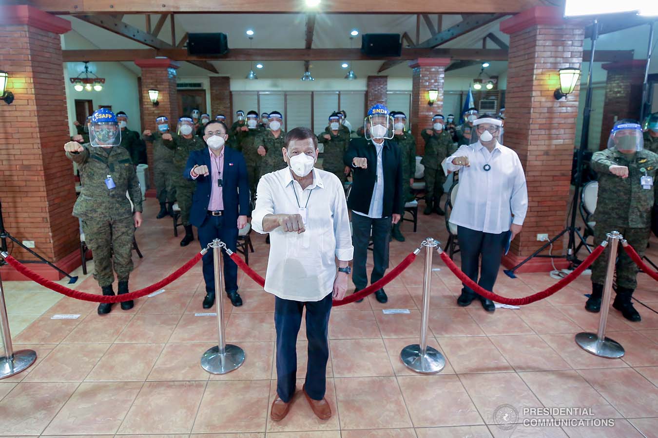President Rodrigo Roa Duterte strikes his signature pose with some members of his Cabinet, officers of the Armed Forces of the Philippines and Senator Christopher "Bong" Go during a meeting at the Malago Clubhouse in Malacañang, Manila on May 26, 2020. KARL NORMAN ALONZO/PRESIDENTIAL PHOTO