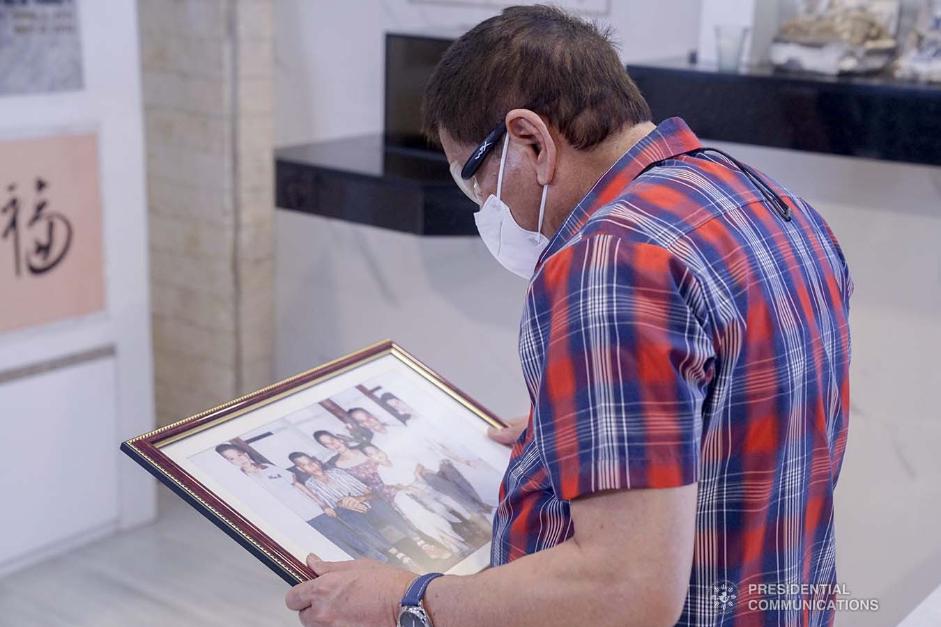 President Rodrigo Roa Duterte glances at the old printed photo of his family as he visits the resting place of his parents, Vicente Duterte, the former governor of then undivided Davao Province, and Soledad Duterte, one of Davao’s respected civic leaders, at the Roman Catholic Cemetery in Davao City on October 28, 2020. The President, as an annual tradition, visits the family mausoleum during All Saints or All Souls Day even when he was still mayor of Davao City. ARMAN BAYLON/ PRESIDENTIAL PHOTO