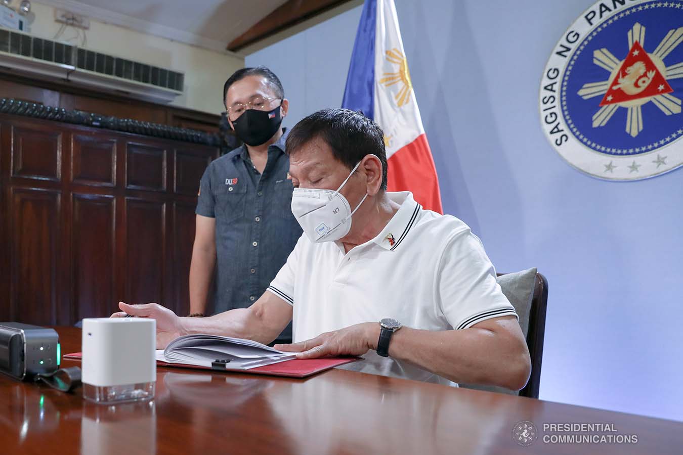 President Rodrigo Roa Duterte signs into law the Coronavirus Disease 2019 (COVID-19) Vaccination Program Act of 2021 at the Malacañang Golf (Malago) Clubhouse in Malacañang Park, Manila on February 26, 2021. The said law would expedite the procurement and administration of vaccines for the protection against COVID-19. It also covers the creation of an indemnity fund to cover compensation for those who would experience serious adverse effects to the vaccine. The President is accompanied by Senator Christopher Lawrence Go. KARL NORMAN ALONZO/ PRESIDENTIAL PHOTO