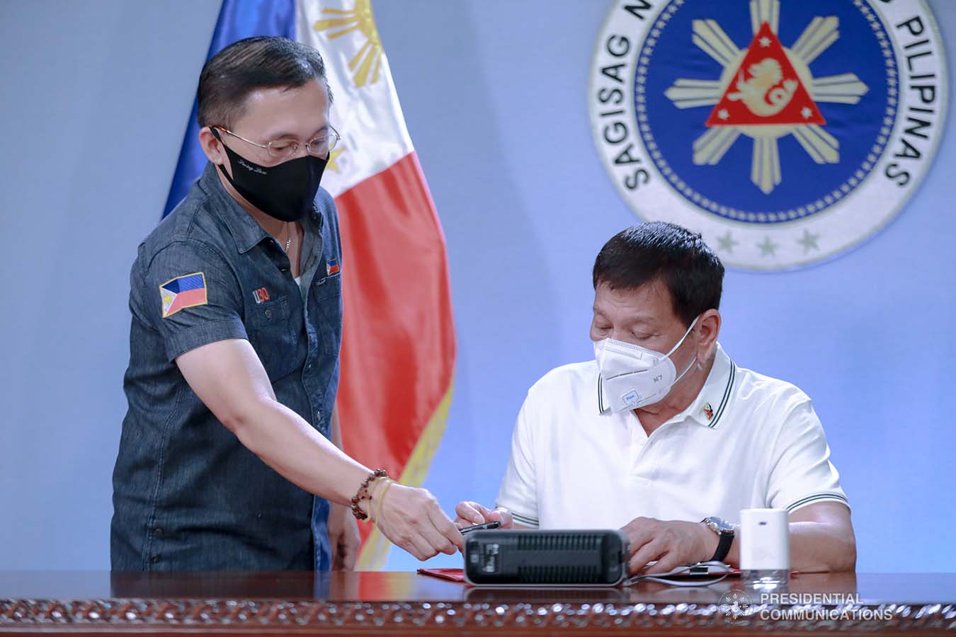President Rodrigo Roa Duterte signs into law the Coronavirus Disease 2019 (COVID-19) Vaccination Program Act of 2021 at the Malacañang Golf (Malago) Clubhouse in Malacañang Park, Manila on February 26, 2021. The said law would expedite the procurement and administration of vaccines for the protection against COVID-19. It also covers the creation of an indemnity fund to cover compensation for those who would experience serious adverse effects to the vaccine. The President is accompanied by Senator Christopher Lawrence Go. ACE MORANDANTE/ PRESIDENTIAL PHOTO