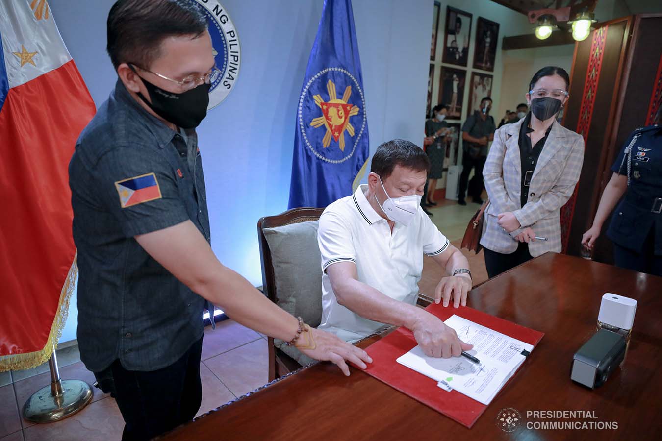 President Rodrigo Roa Duterte signs into law the Coronavirus Disease 2019 (COVID-19) Vaccination Program Act of 2021 at the Malacañang Golf (Malago) Clubhouse in Malacañang Park, Manila on February 26, 2021. The said law would expedite the procurement and administration of vaccines for the protection against COVID-19. It also covers the creation of an indemnity fund to cover compensation for those who would experience serious adverse effects to the vaccine. The President is accompanied by Senator Christopher Lawrence Go. ACE MORANDANTE/ PRESIDENTIAL PHOTO