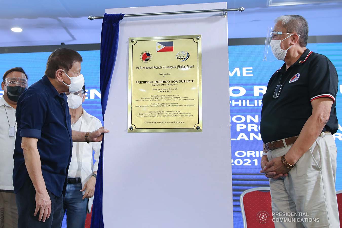 President Rodrigo Roa Duterte, assisted by Transportation Secretary Arthur Tugade, looks at the marker as he leads the unveiling ceremony of the development projects at Dumaguete (Sibulan) Airport in Sibulan, Negros Oriental on March 11, 2021. VALERIE ESCALERA/ PRESIDENTIAL PHOTO