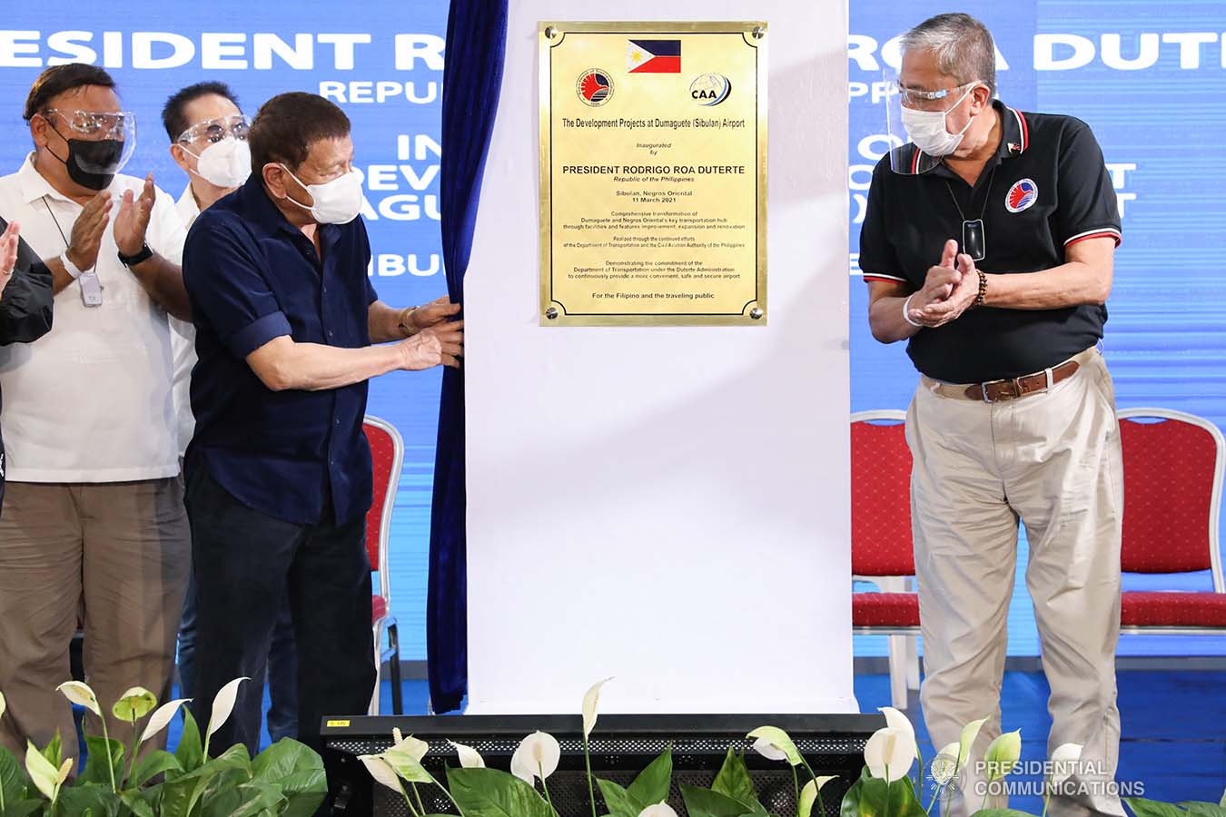 President Rodrigo Roa Duterte, assisted by Transportation Secretary Arthur Tugade, looks at the marker as he leads the unveiling ceremony of the development projects at Dumaguete (Sibulan) Airport in Sibulan, Negros Oriental on March 11, 2021. TOTO LOZANO/ PRESIDENTIAL PHOTO