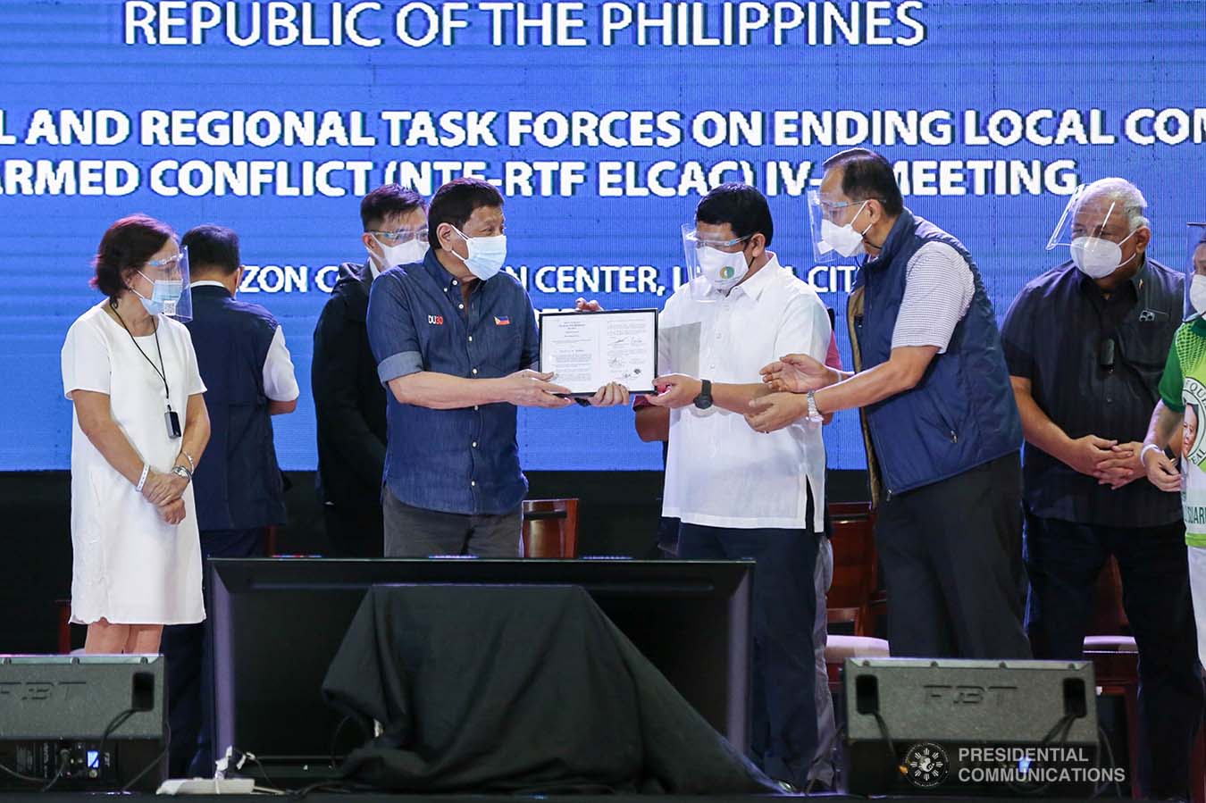 President Rodrigo Roa Duterte hands over the copy of Republic Act 11524 or the Coconut Farmers and Industry Trust Fund Act that he received from Senator Cynthia Villar and Representative Alan Peter Cayetano to Philippine Coconut Administrator Benjamin Madrigal Jr. during the joint National Task Force-Regional Task Force to End Local Communist Armed Conflict IV-A meeting at the Quezon Convention Center in Lucena City, Quezon on October 21, 2021. ALBERTO ALCAIN/ PRESIDENTIAL PHOTO