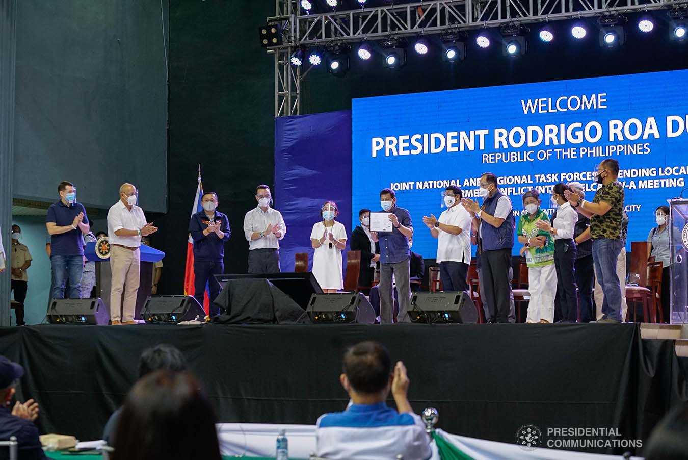 President Rodrigo Roa Duterte shows the copy of Republic Act 11524 or the Coconut Farmers and Industry Trust Fund Act that he received from Senator Cynthia Villar and Representative Alan Peter Cayetano before handing it over to Philippine Coconut Administrator Benjamin Madrigal Jr. during the joint National Task Force-Regional Task Force to End Local Communist Armed Conflict IV-A meeting at the Quezon Convention Center in Lucena City, Quezon on October 21, 2021. KING RODRIGUEZ/ PRESIDENTIAL PHOTO