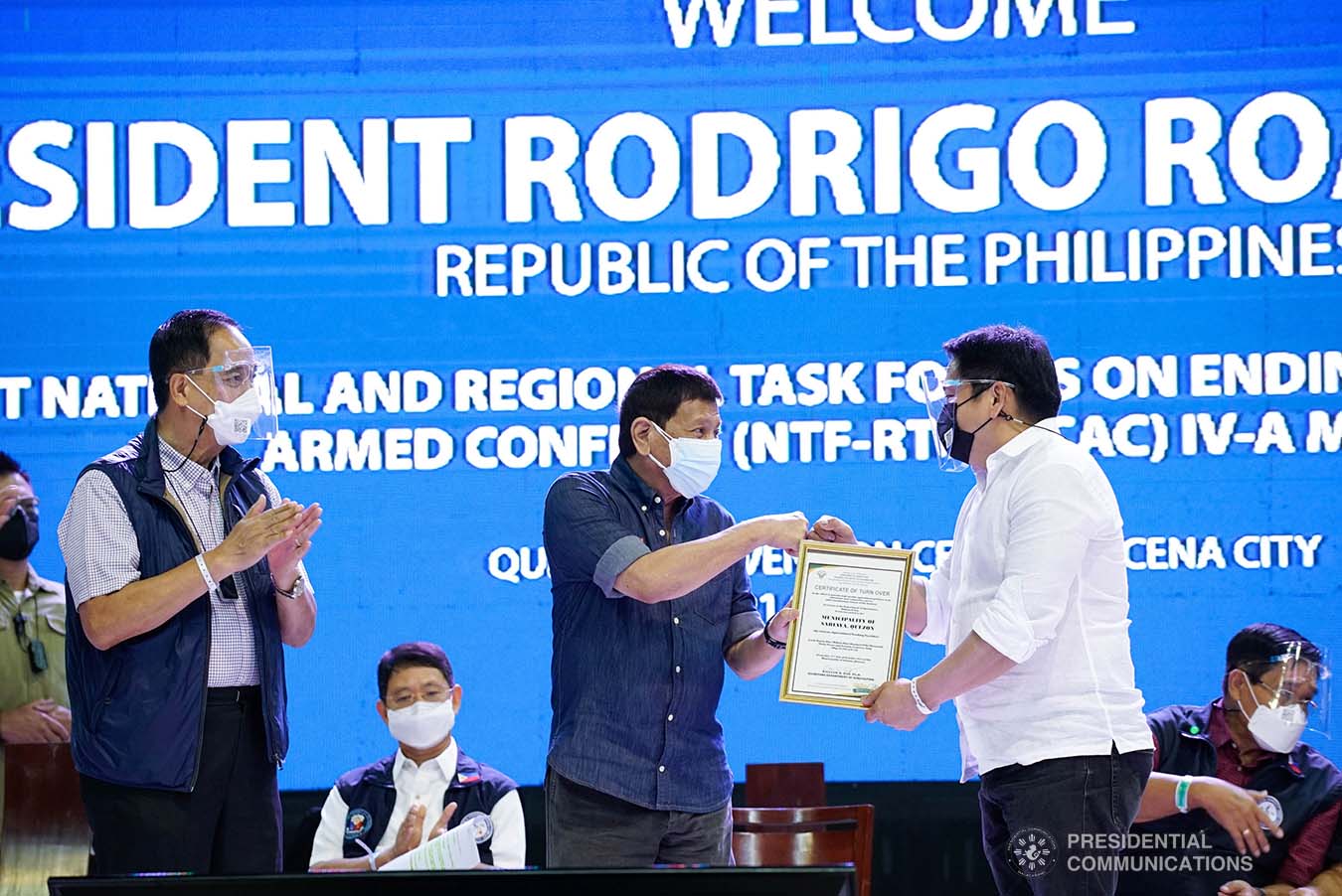President Rodrigo Roa Duterte hands over the certificate of management of the Sariaya Agricultural Trading Center and Facilities he received from Agriculture Secretary William Dar to the Local Government Unit of Sariaya during the joint National Task Force-Regional Task Force to End Local Communist Armed Conflict IV-A meeting at the Quezon Convention Center in Lucena City, Quezon on October 21, 2021. KING RODRIGUEZ/ PRESIDENTIAL PHOTO