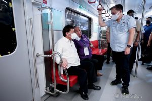 President Rodrigo Roa Duterte discusses matters with Senator Christopher Lawrence "Bong" Go and Transportation Secretary Arthur Tugade following the unveiling of brand-new train sets for Metro Rail Transit Line 7 (MRT-7) at the MRT-7 tracks along Commonwealth Avenue in Diliman, Quezon City on December 16, 2021. ALBERTO ALCAIN/ PRESIDENTIAL PHOTO
